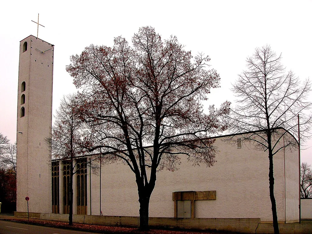 Kath. Pfarrkirche zum Heiligsten Erlöser; Saalbau auf dreieckigem Grundriss, mit freistehendem Campanile und nördlich angebauter Kapelle, von Thomas Wechs, 1959-61; mit Ausstattung; Pfarrhaus und Pfarrsaal, angeschlossene erdgeschossige Nebengebäuden mit Flachdach.