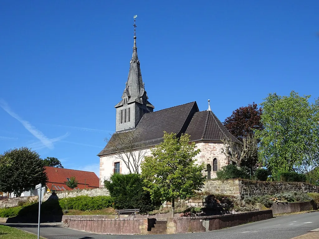 Die evangelische Kirche von Thurnhosbach. Thurnhosbach ist ein Stadtteil von Sontra im nordhessischen Werra-Meißner-Kreis. "An erhöhter Stelle befindliche Kirche mit einem ehemaligen Chor aus dem 14. Jahrhundert und einem Schiff aus dem 16. Jahrhundert. Im Jahr 1899 wurde die Kirche durch ein Feuer vernichtet; das erhaltene Mauerwerk zum Wiederaufbau verwendet, der 1900 / 01 nach den Plänen G. Schönermarks fertiggestellt wurde. Es entstand ein gotisierender Saalbau mit eingezogenem Chor in polygonalen Schluss. Über der Eingangsseite erwächst ein stattlicher Dachreiter, dessen Erker von Fialen und Kreuzblumen bekrönt werden." Text aus: Denkmaltopographie Bundesrepublik Deutschland, Kulturdenkmäler in Hessen. Werra-Meißner-Kreis I, Altkreis Eschwege. Peer Zietz, Thomas Wiegand, Braunschweig: Vieweg Verlag, 1991, ISBN 3-528-06240-1.
