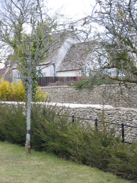 View northwest across private garden walls to St Osmund's chapel, Tarlton, Gloucestershire. Access is between the wall and railings in the foreground. This access is over land owned by the house out of view to the left. It is not a public footpath. There is no public access over the track between the two foreground walls, which passes the church.