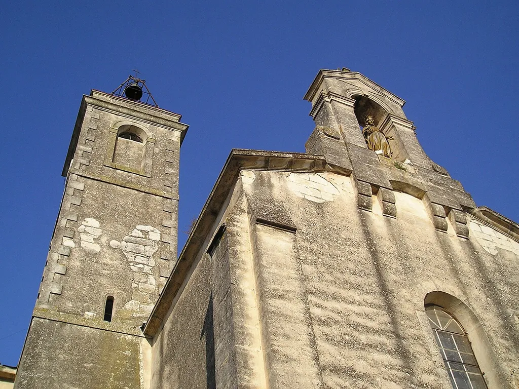 In Hérault, France, the front of the church of Galargues, the bell tower and a statue of the Mary (?)