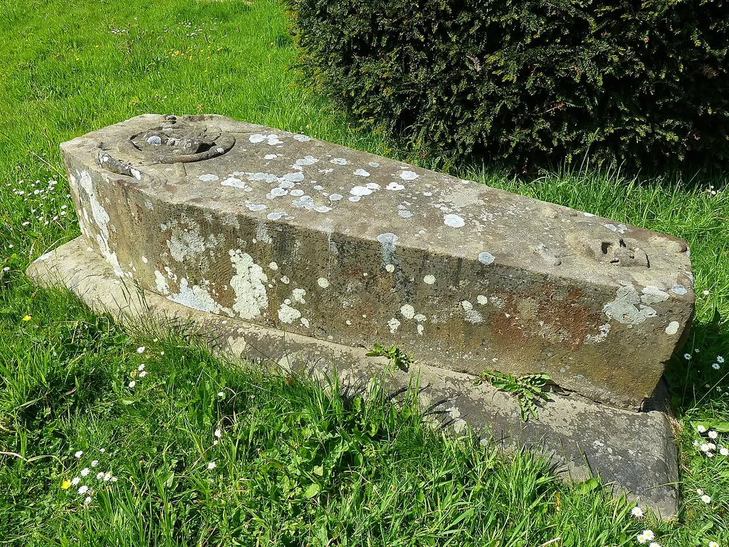 Photograph of a memorial in a churchyard in the form of a gravestone in the shape of a coffin, St Anne's Church, Baslow, Derbyshire, England