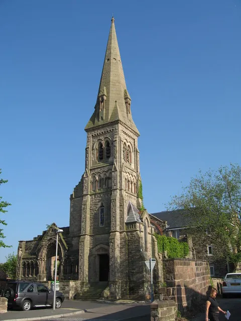 The remains of Trinity Methodist Church, Frodsham, Cheshire, seen from the southwest from Trinity Gardens. Most of the building was demolished in the 1970s, leaving only the southwest tower, spire and some of the walls. An apartment block now adjoins the ruins.