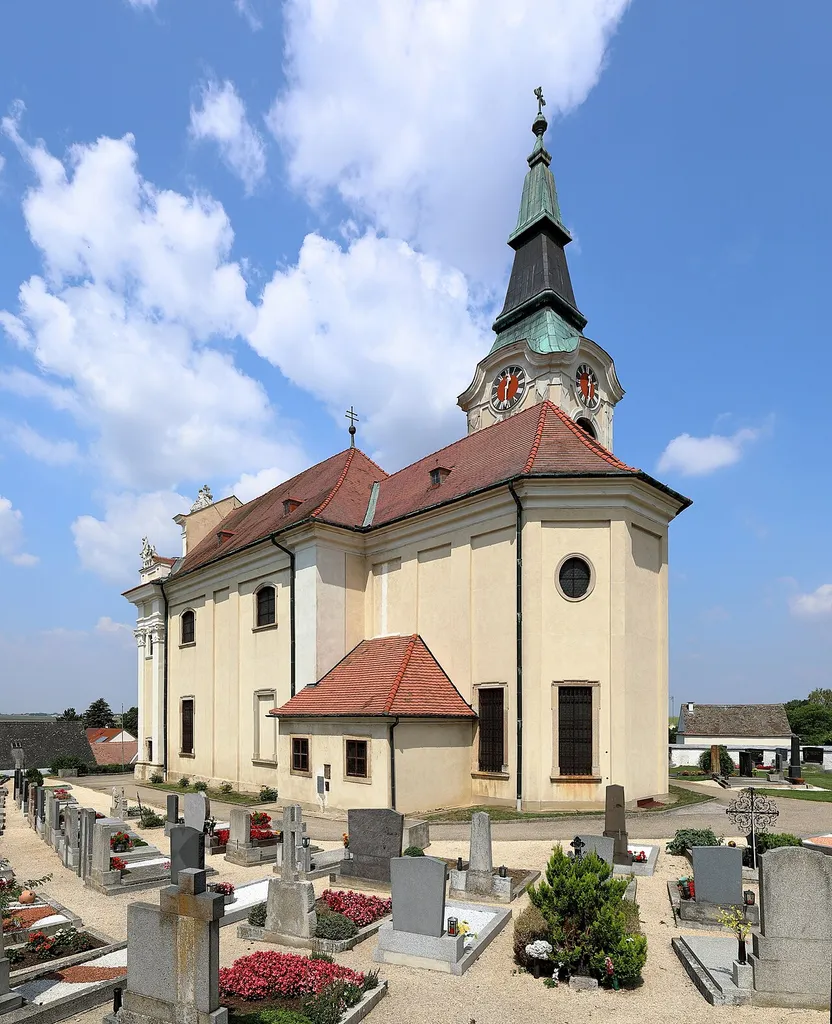 Südostansicht der röm.-kath. Pfarrkirche hl. Georg in Aspersdorf, ein Ortsteil der niederösterreichischen Stadtgemeinde Hollabrunn. Die spätbarocke Saalkirche mit im Kern gotischem Chor sowie Nordturm wurde in der ersten Hälfte des 18. Jahrhunderts barockisiert bzw. im Prinzip neu errichtet.
