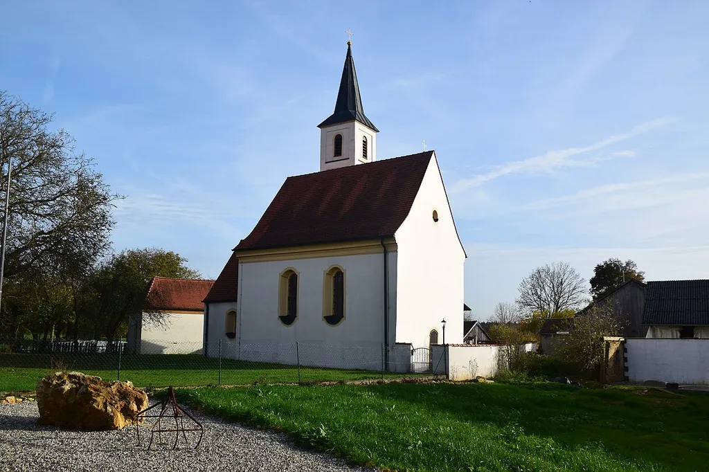 Saalkirche mit Steildach und eingezogenem Rechteckchor, schlanker Flankenturm mit Spitzhelm