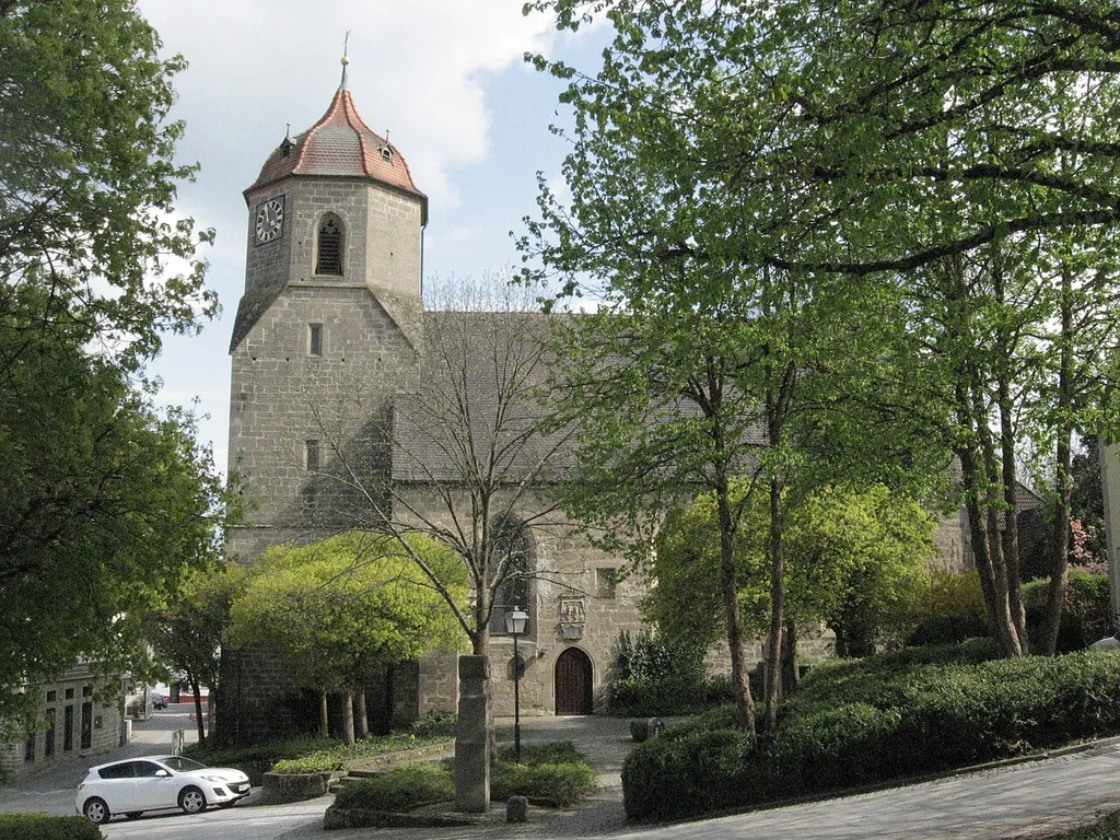 Blick im Frühjahr vom Eingang des Obersontheimer Schlosses auf die evangelische Pfarrkirche des Ortes, davor das Schubartdenkmal.