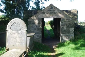 Lychgate and churchyard wall to Church of St Tudwen