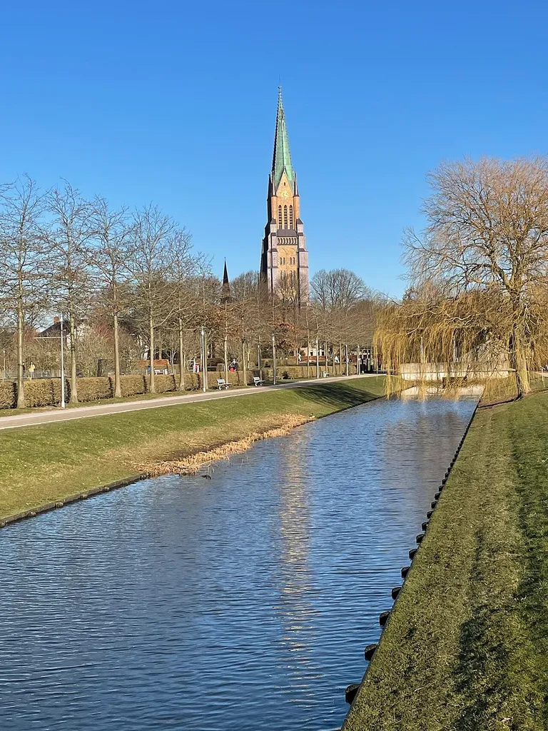 Blick von den Königswiesen auf den Schleswiger Dom mit Spiegelung im Wasser des Schleikanals