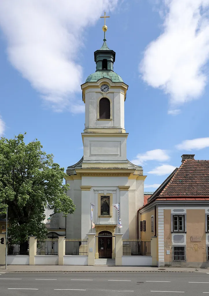 Westansicht der Franziskanerkloster-, Wallfahrts- und ehemalige Pfarrkirche hll. Maria Magdalena und Maria in der niederösterreichischen Marktgemeinde Maria Enzersdorf.1454 erfolgte die Gründung des Klosters. Klostergebäude und Kirche waren 1472 vollendet, bei beiden Türkenbelagerungen (1529, 1683) jeweils zerstört. Von 1727 bis 1729 erfolgte Wiedererrichtung und Erweiterung. Eine weitere Erweiterung fand unter Richard Jordan von 1907 bis 1909 statt. Nachdem die Kirche 1784 eine Pfarrkirche wurde (bis 2014), ersetzte man 1788 den Dachreiter durch einen 38 m hohen Kirchturm.