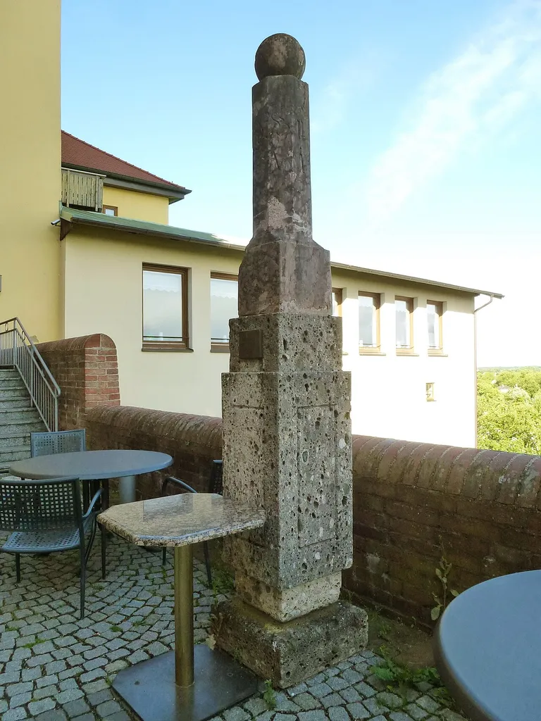 Dachau, Konrad-Adenauer-Str. 6: Säule aus rotem Marmor auf Tuffsteinsockel mit Metalltafel (s. Bild 005). Das eingemeißelte Datum 1819 ist infolge der kräftigen Marmorierung der Säule allerdings kaum lesbar.