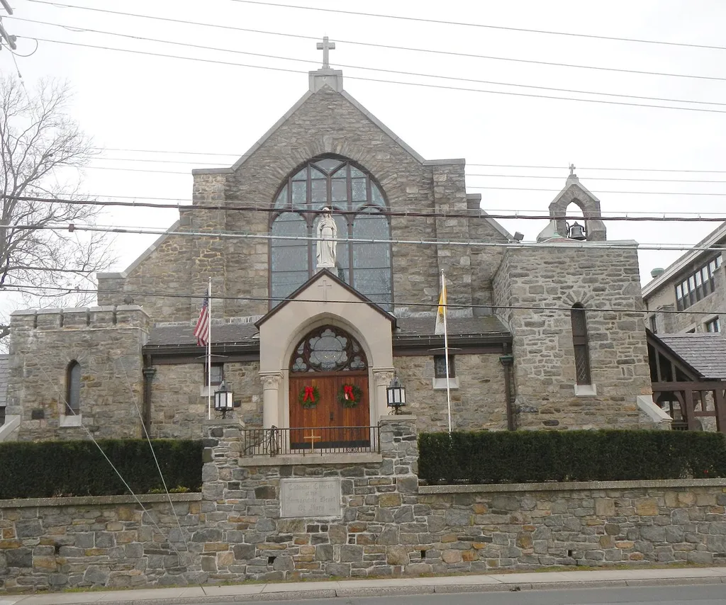 Looking east across White Plains Road at Catholic church on a cloudy afternoon.