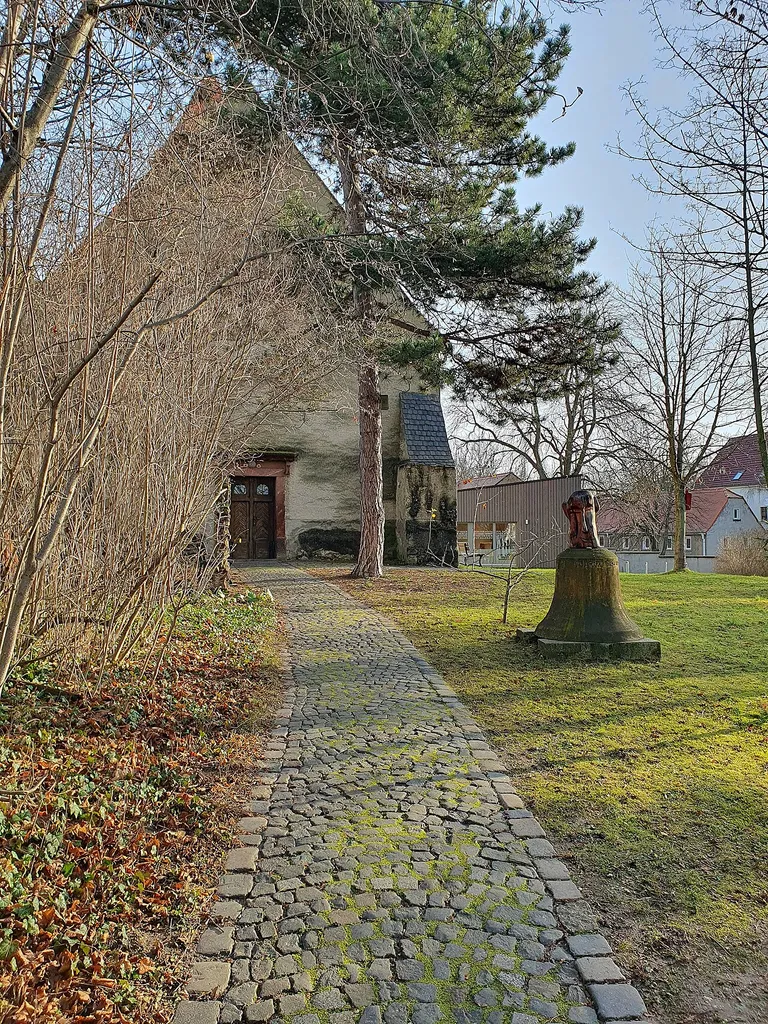 Kirchhof Zuckelhausen - Ansicht des Westeingang zur Kirche mit alter Glocke