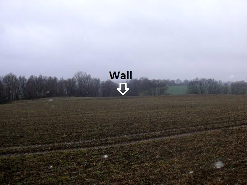 Burgwall im Gelände. Durch die Landwirtschaft fast eingeebnet.