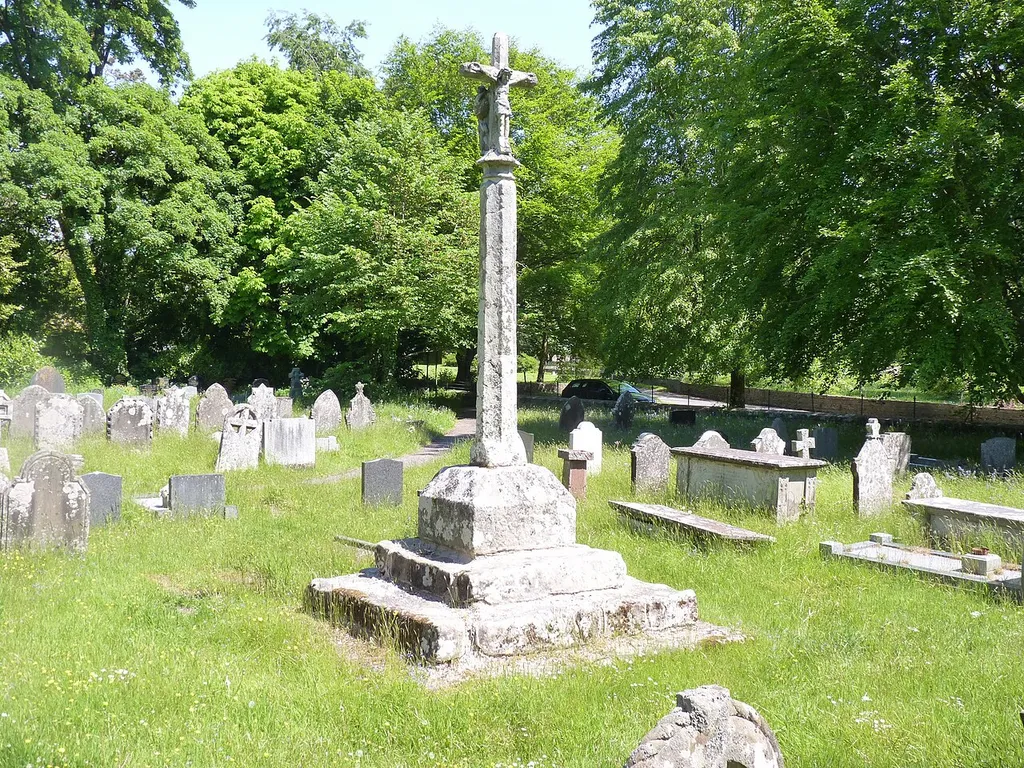 Medieval cross with part of its original finial. It now has a crucifix and a Madonna and child statues on the top.