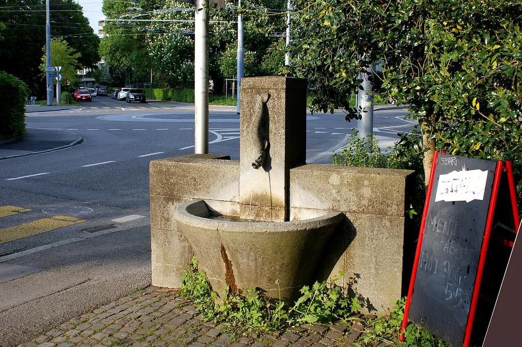 Brunnen Freiburgstrasse Ecke Friedbühlstrasse mit Verkehrskreisel im Hintergrund.