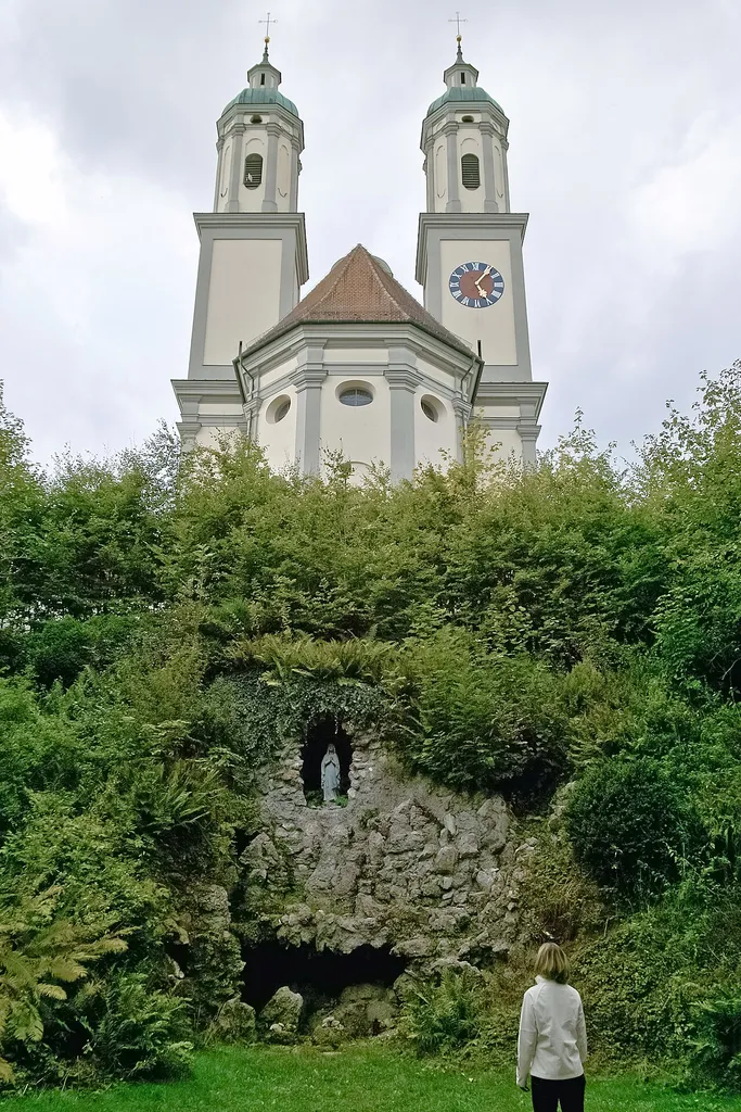 Ehemalige Abteikirche St. Johannes der Täufer, jetzt katholische Pfarrkirche. Zu Füßen der Klosterkirche die Mariengrotte.