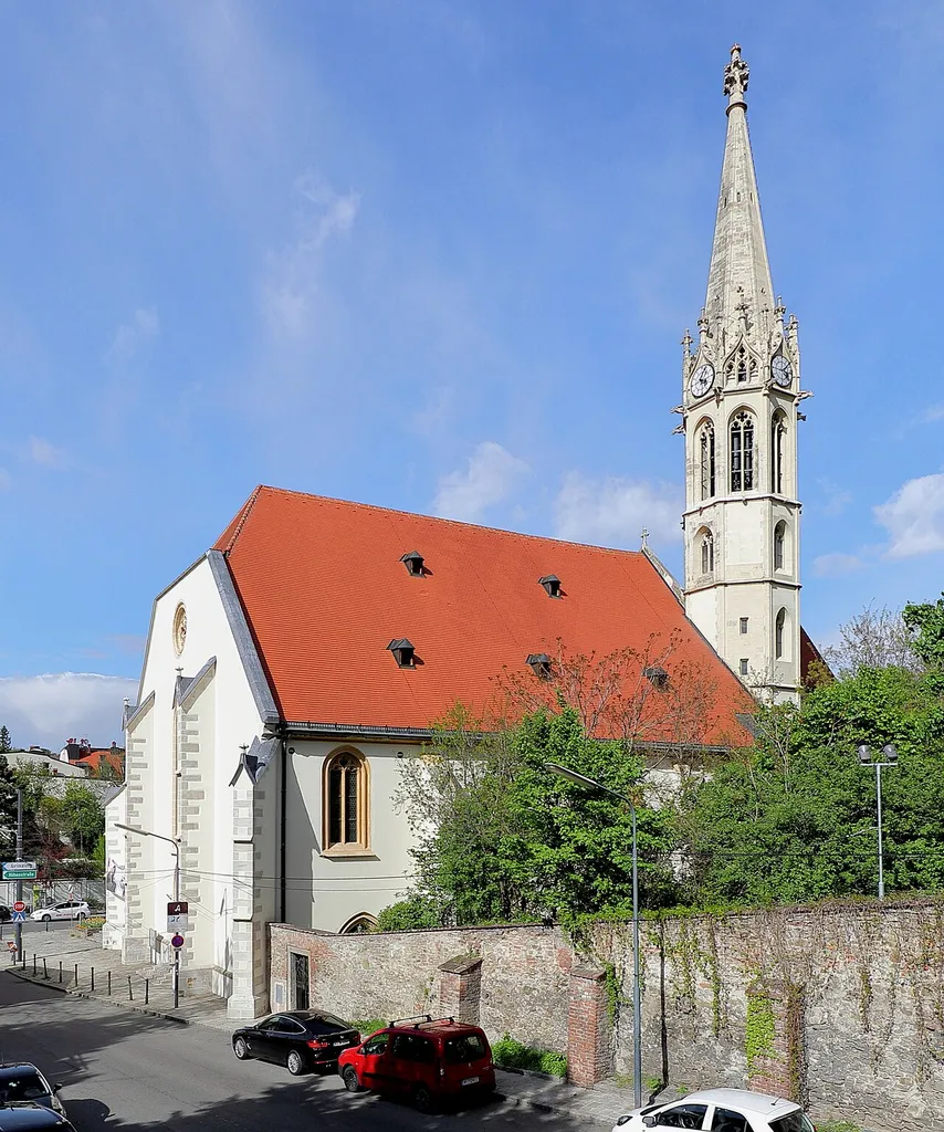 Die Südwestansicht der Pfarrkirche St. Michael in Heiligenstadt, ein Bezirksteil des 19. Wiener Gemeindebezirkes Döbling.Ein dreischiffige Staffelkirche, die unter Einbeziehung der Grundmauern und des Chores der Vorgängerkirche im neugotischen Stil und ähnlich der Vorgängerkirche (bis auf den Turm) nach Plänen von Richard Jordan, unter Beteiligung von Martin und Josef Schömer, ab 1894 errichtet und am 26. Mai 1898 eingeweiht wurde.