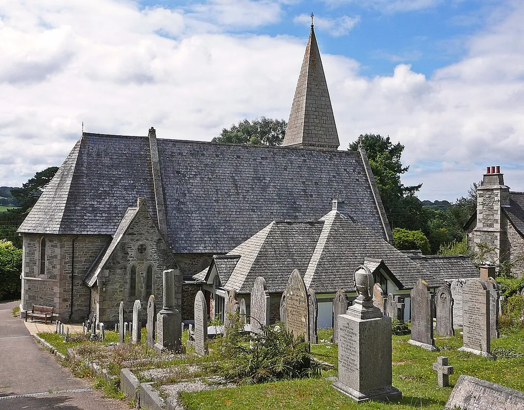 1855 by J. L. Pearson. Coursed slatestone with granite quoins, jambstones, plinth copings, string and ashlar upper stage of tower including steep pyramidal spire. Very steeply pitched dry Delabole slate roofs over nave, chancel and porch. Granite copings to nave and porch and polygonal roof over chancel.