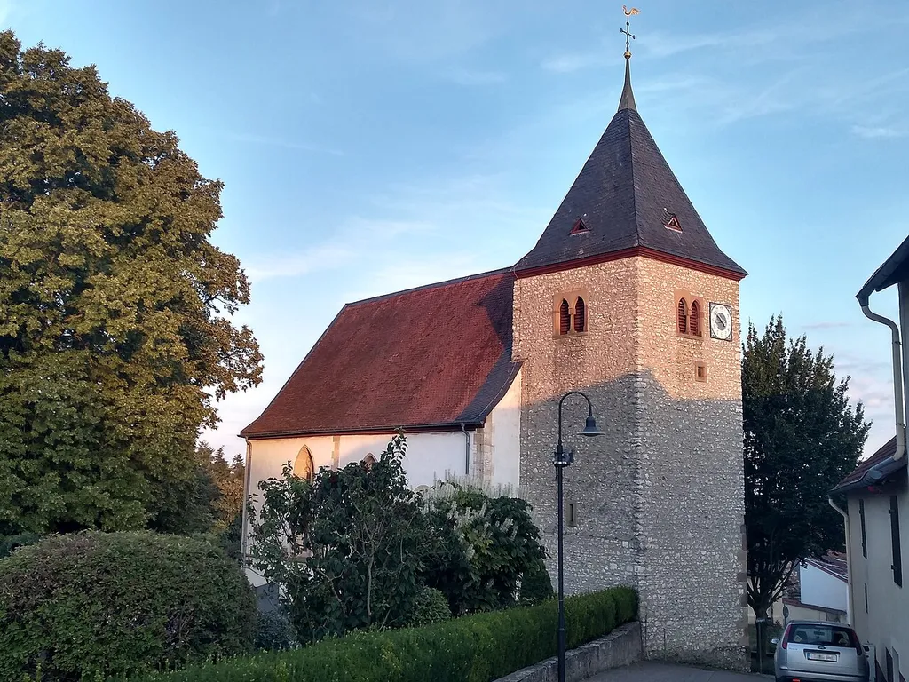 Nordöstliche Ansicht der evangelischen Pfarrkirche in der Kirchgasse 17, Hangen-Weisheim, Verbandsgemeinde Wonnegau, Landkreis Alzey-Worms, Rheinland-Pfalz, Deutschland. Kulturdenkmal gemäß Denkmalliste des Landes Rheinland-Pfalz (Stand: 31. Juli 2018). Westturm, Langhausnordwand, Chor spätromanisch (12. oder 13. Jahrhundert); 1434 spätgotische Erweiterung, nach Brand 1689 vereinfachte Wiederherstellung 1725; auf dem Friedhof Grabsteine der zweiten Hälfte des 19. Jahrhunderts.