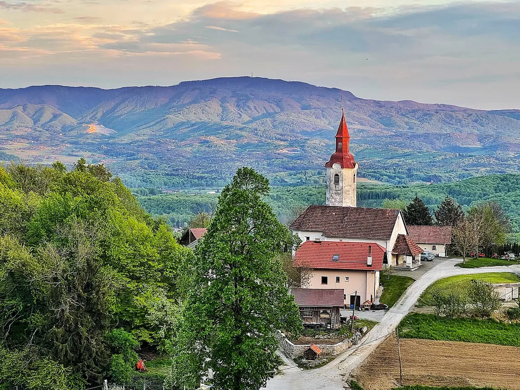 Koglo (417m) with Church of St. Lenart, behind you can see Gorjanci Hills with Trdina Peak (1178m).