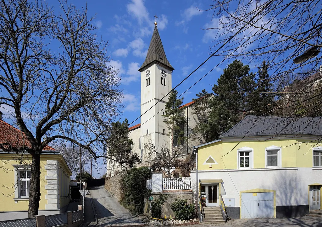 Südansicht der katholischen Pfarrkirche hl. Leonhard in Matzen, ein Ortsteil der niederösterreichischen Marktgemeinde Matzen-Raggendorf. Ursprünglich ein gotischer Bau, der um 1700 barockisiert wurde. In den Jahren 1958/59 wurde nach Plänen des Architekten Josef Vytiska ein moderner Erweiterungsbau mit breitgelagertem Langhaus errichtet.