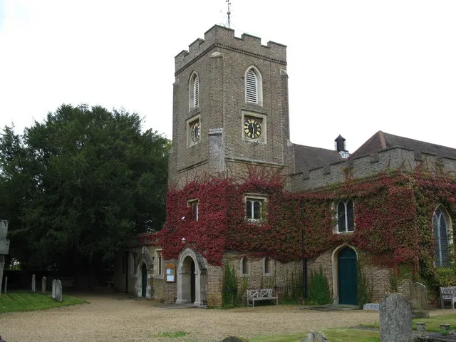 West tower of the parish church of St Michael, Sunninghill, Berkshire, seen from the southwest. On the left is a hollow yew tree said to be more than 1000 years old. It has an iron girdle holding it together just above head height.