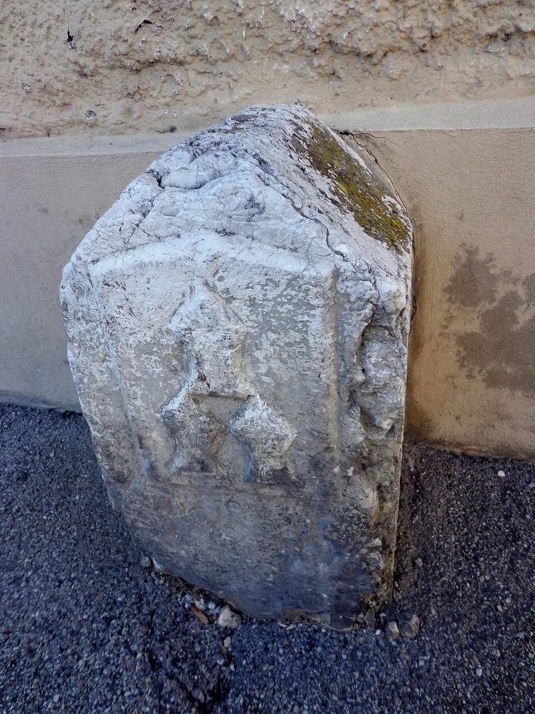Dieser Stein ist ein geschütztes Baudenkmal. Dieser unscheinbare Stein direkt an der Hauswand trägt die drei Helme von Landshut, aber sonst kein Merkmal.