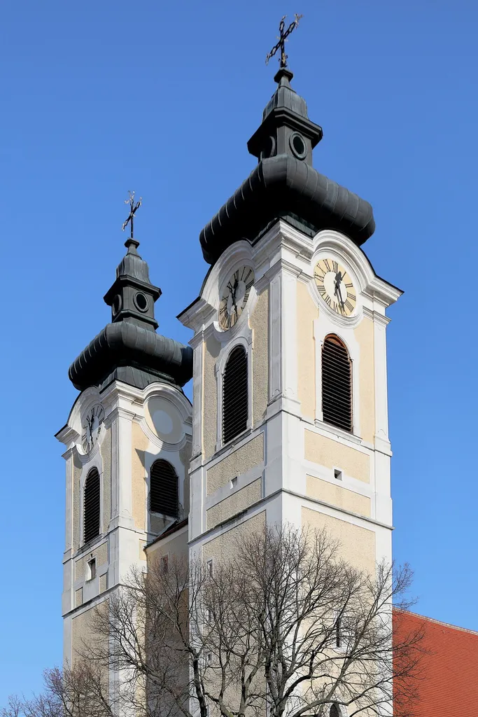 Südwestansicht der Doppeltürme der röm.-kath. Stadtpfarrkirche hl. Stephan in der niederösterreichischen Stadtgemeinde Tulln an der Donau.Im unteren Bereich Teil des romanischen Westwerkes. Der Nordturm wurde um 1600 erneuert, nachdem der Vorgängerturm teilweise eingestürzt ist. Nach einem Brand 1752 wurden die Türme im barocken Stil erhöht und durch einen gemauerten Gang unterhalb der Glockenstube miteinander verbunden.