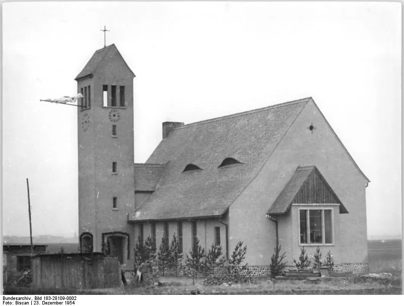 For documentary purposes the German Federal Archive often retained the original image captions, which may be erroneous, biased, obsolete or politically extreme. Zentralbild-Biscan Wjt-Qu 2 Mot. 23.12.1954 Kirchenweihe in Magdeburg-Nordwest Die zweite nach 1900 in Magdeburg erbaute evangelische Kirche, die Kreuzkirche in Magdeburg-Nordwest wurde jetzt geweiht. Der Kirchenneubau wurde 1953-1954 nach einem Entwurf des Kirchen-Oberbaurates Seebach ausgeführt und bietet 260 Gläubigen Platz. UBz Blick auf die neuerbaute Kreuz-Kirche am nordwestlichen Stadtrand Magdeburgs.