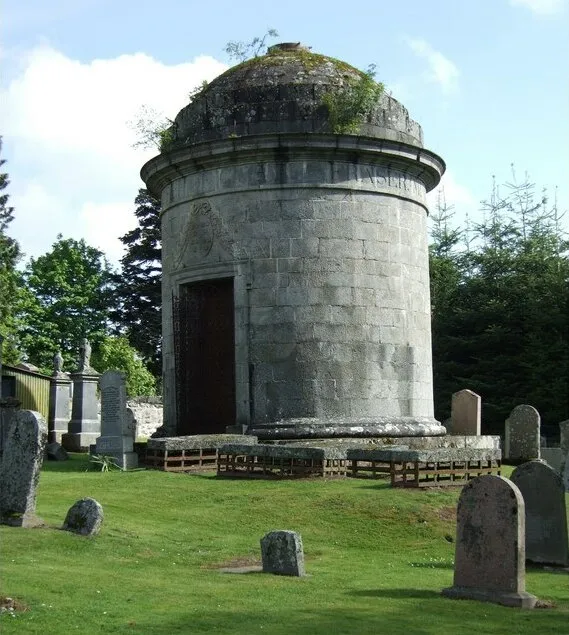 Fraser Mausoleum, Cluny kirkyard. The inscription beneath the dome reads 'ELYZA FRASER OF CASTLE FRASER MDCCCVIII'. The escutcheon above the door bears the Fraser Coat of Arms with the motto 'Je suis prest' (I am ready). There are four mortsafes close to the door to the mausoleum. See link at http://www.undiscoveredscotland.co.uk/monymusk/clunykirkyard/index.html
