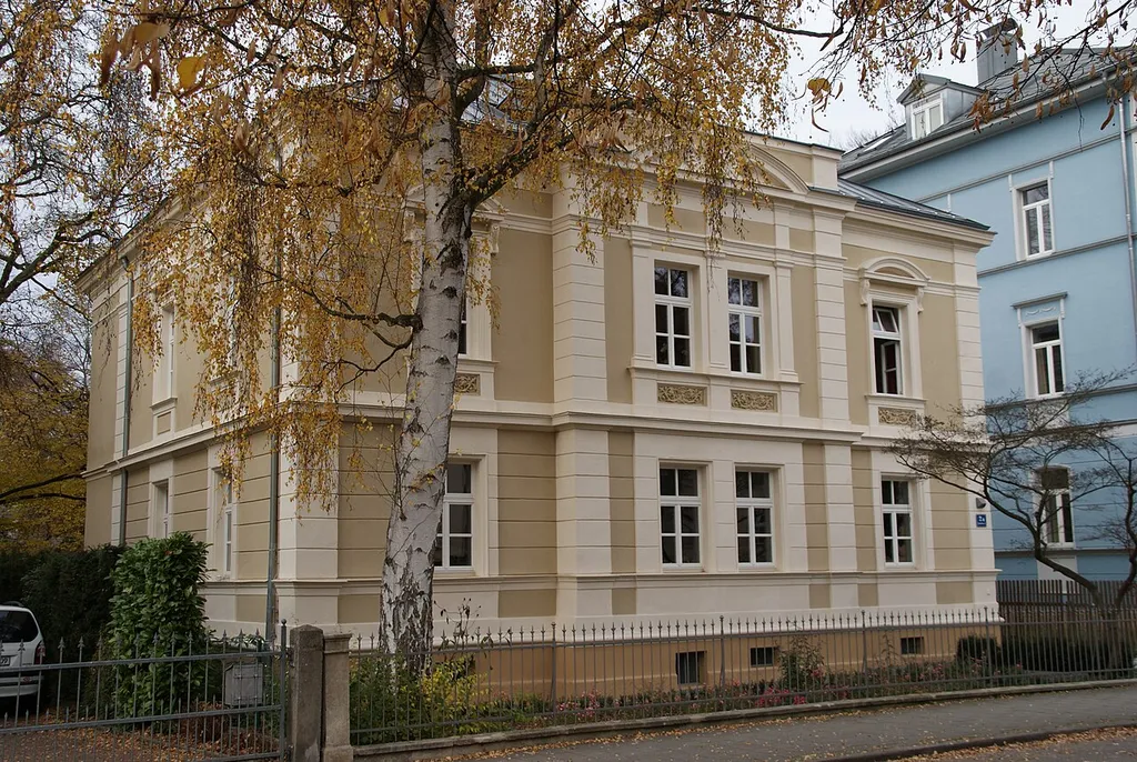 Evang.-Luth. Pfarramt Dreieinigkeitskirche, ehem. Villa, zweigeschossiger Walmdachbau mit Mittelrisalit und Sprenggiebel, spätklassizistisch, Fassadengliederungen in Werkstein, Neurenaissance, 1875 von Adrian Zinstag; Brunnentrog, reliefert, Sandstein, Renaissance, bez. 1591 This is a photograph of an architectural monument.It is on the list of cultural monuments of Bayern, no. D-3-62-000-273.