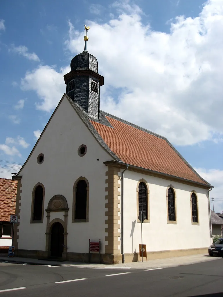 Evangelische Kirche Ludwigstraße 1 in Ottersheim; dreiachsiger Saalbau, bezeichnet 1813 und 1816; über dem Portal mit Chronogramm bezeichnet: DIE•BÜRGER•DER•REFOR-/MIRTEN•GEMEINDE OTTERS-/HEIM•HABEN•DIESE•KIRCHE•VON• / GRUND AUF•NEUERBAUET•IM•JAHR NACH / CHRISTI GEBVRT EINTAUVSEN•ACHT-/HUNDERT•UND DREIZEHN•1813