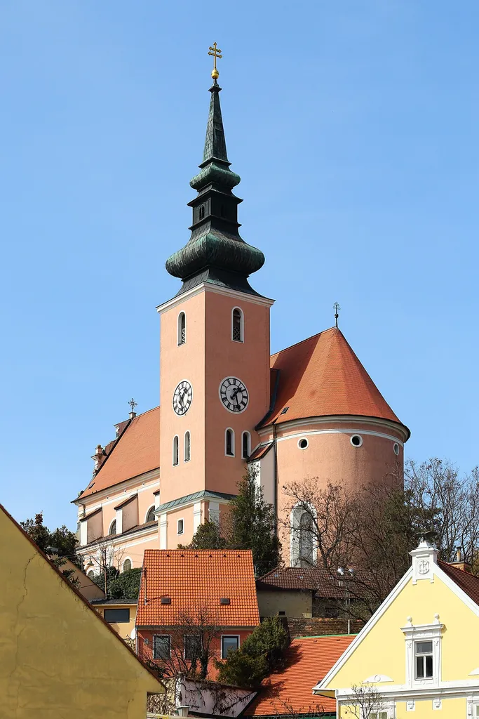 Südostansicht der römisch-katholischen Pfarrkirche hl. Johannes der Täufer in der niederösterreichischen Stadt Poysdorf.Die in erhöhter Lage im Norden des Ortes errichtete Kirche ist ein frühbarocker Bau. Er wurde von 1629 bis 1635 errichtet, im Jahr 1640 geweiht und ist von Resten einer wehrhaften Kirchenmauer umgeben. Der Turm wurde 1864 neu erbaut.
