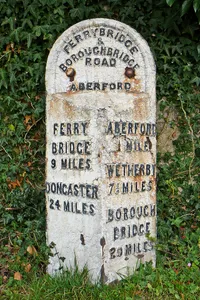 Milepost Against Wall Of Garden To St Wilfrids Roman Catholic Church