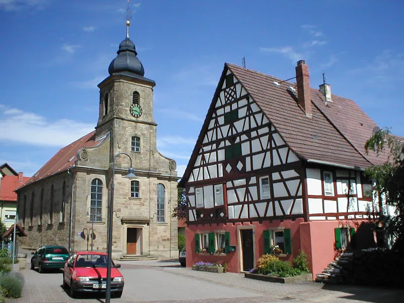 Szene in der Ortsmitte von Sinsheim-Weiler mit Kirche und Fachwerkhaus von 1607