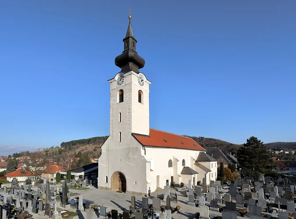 Südwestansicht der röm.-kath. Pfarrkirche hl. Margaretha in der niederösterreichischen Marktgemeinde Sieghartskirchen.Die Kirche ist auf einer Anhöhe errichtet und von einem Friedhof mit Befestigungsmauer umgeben. Die im Kern spätromanische und gotisch überbaute Saalkirche hat einen mächtigen romanischen Westturm sowie einen polygonal geschlossenen Chor.