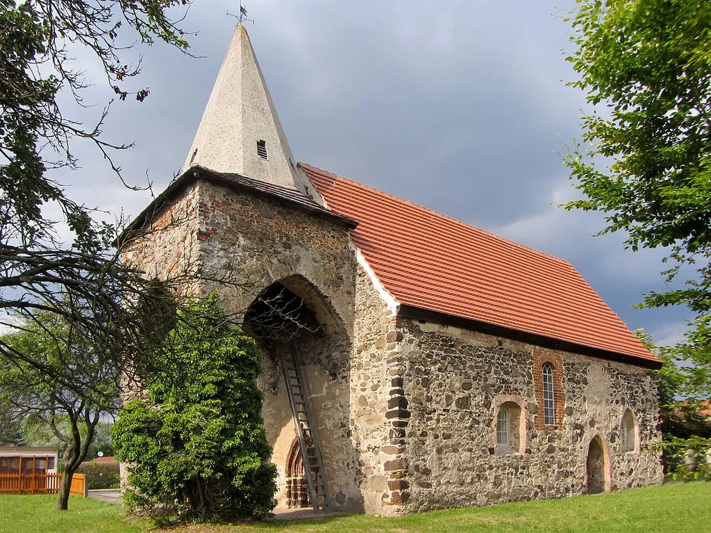 Kirche Walddrehna: Es handelt sich dabei um eine kleine Kirche aus dem 13. Jahrhundert, der eine ungewöhnliche, nach drei Seiten hin offene Vorhalle als Glockenträger mit massivem Kegelhelm aus Backstein angefügt wurde. Deren hohe Spitzbogenarkaden ruhen auf zwei aus Feldsteinen gemauerten Rundpfeilern, die von einigen Historikern als Überreste einer vorchristlichen Weihestätte angesehen werden. This is a picture of the Brandenburger Baudenkmal (cultural heritage monument) with the ID 09140297 (Wikidata)