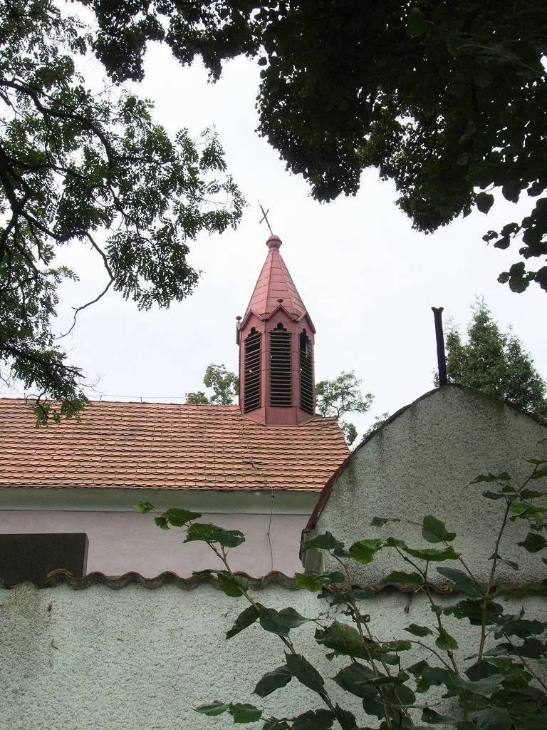 Tower of the Holy Trinity Church in the village of Neznašov, České Budějovice District, Czech Republic with a leaning cross