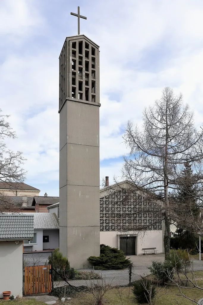 Westansicht der evangelische Christuskirche in der niederösterreichischen Stadtgemeinde Bad Vöslau. Der Kirchenbau als funktionalistischer Betonbau mit einem Turm wurde 1966 nach den Plänen des Architekten Herbert Fritscher-Notthaft erbaut.