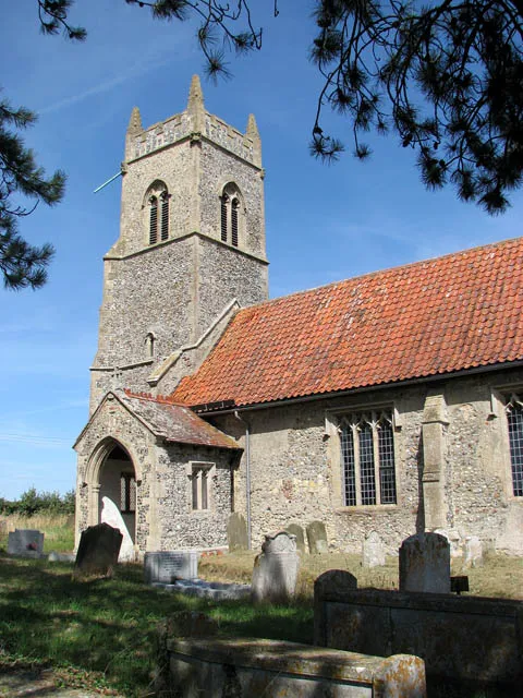 St Peter's church - porch and tower. St Peter's church > 1455212 is located on an elevation just south of Brooke Road. The building dates mainly from the 14th century but the south door sheltered by the porch is framed by a magnificent Norman arch > 1056371. The interior contains several medieval survivals such as the C15 rood screen, albeit stripped of all its original colour > 1455251. Attached to it is an hour glass stand > 1455259. A C15 piscina > 1455261 with ogee hood moulds and carved faces of children can be seen in the chancel. It still has the original wooden credence shelf. A mural depicting St Christopher, opposite the south doorway, is partially covered by a 19th century wall monument. Beside the modern font underneath the tower there are the remains of a Norman font made of Purbeck marble. A brick-faced wafer oven > 1455273 can be seen beside the font in its original position in the south wall of the tower.