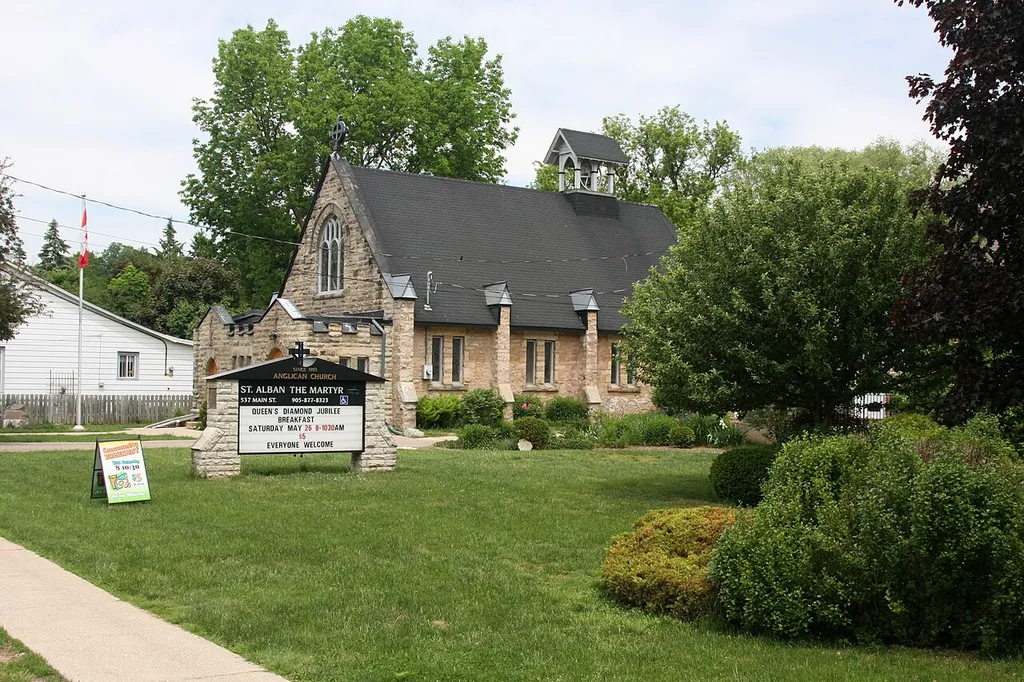 St. Alban the Martyr Anglican Church, 539 Main Street in Glen Williams, Ontario, Canada. The St. Albans Church (539 Main Street) and rectory site (537 Main Street) is made up of lots 1 and 47 of the original Charles Kennedy survey as well as additional land along the Credit River. Lot 1 was first sold in 1838 to George McElvery from Benajah Williams. It passed through several owners and in 1856 was split, with the southerly half eventually being left to the church by Rose Ann McMaster, widow of William McMaster. The first services were held in her house, which had been converted for this purpose. The conerstone of St. Alban the Martyr was laid in 1902, and the church opened in June of following year. The architect was F. S. Baker, the son of a woollen miller in Kilbride, and a friend of Joesph Beaumont. F.S. Baker would later become the 2nd President of the Royal Architectural Institute of Canada from 1910-1912. The adjacent site, Lot 47, was first purchased by Thomas Alexander in 1859 from Charles Williams. Alexander, a Blacksmith, operated a shop on the site for a number of years. The lot was eventually sold to the church and the existing Rectory was built.