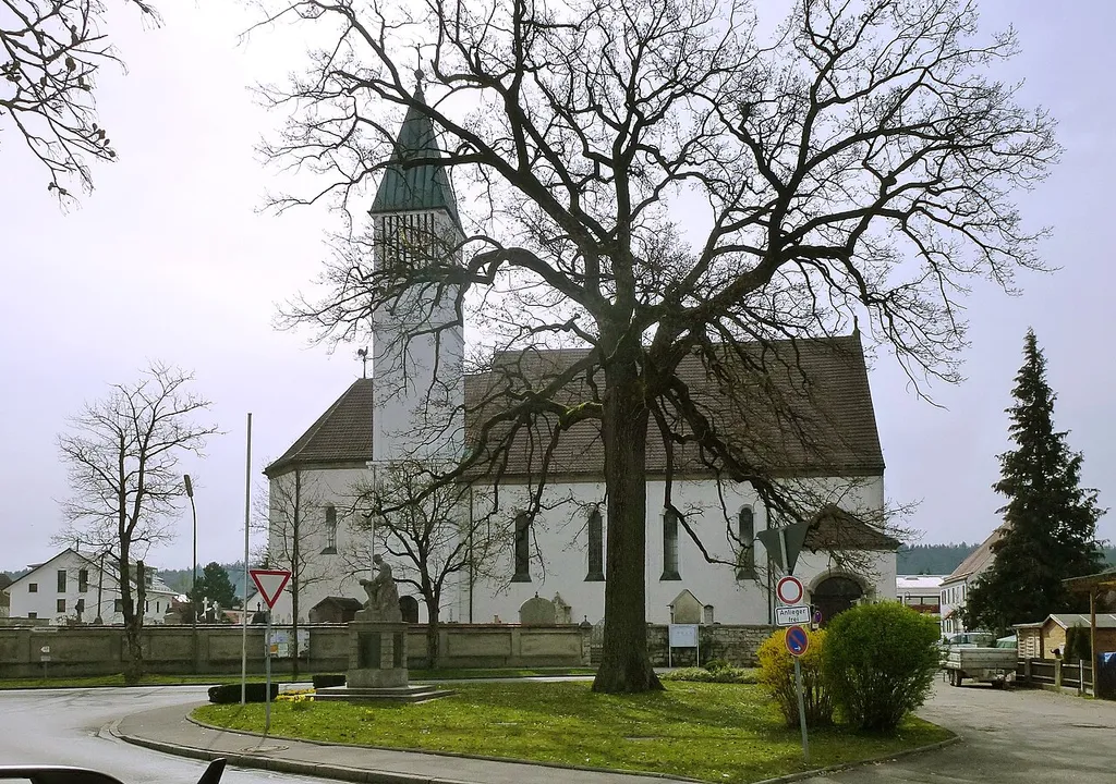 Emmering, katholische Pfarrkirche St. Johann Baptist &amp; Evangelist. Nähe Kirchplatz. Die heutige Kirche wurde 1928 (Grundsteinlegung 15.07.1928) an der Südseite des Turmes der Vorgängerkirche angefügt, für die der Turm aber ein Westturm (und zugleich Eingang) war; sie bedeckt daher heute einen Teil des früheren Friedhofes. Die Namen der so überdeckten Gräber wurden in die Bodenplatten der heutigen Kirche eingraviert. Ansicht von NNW