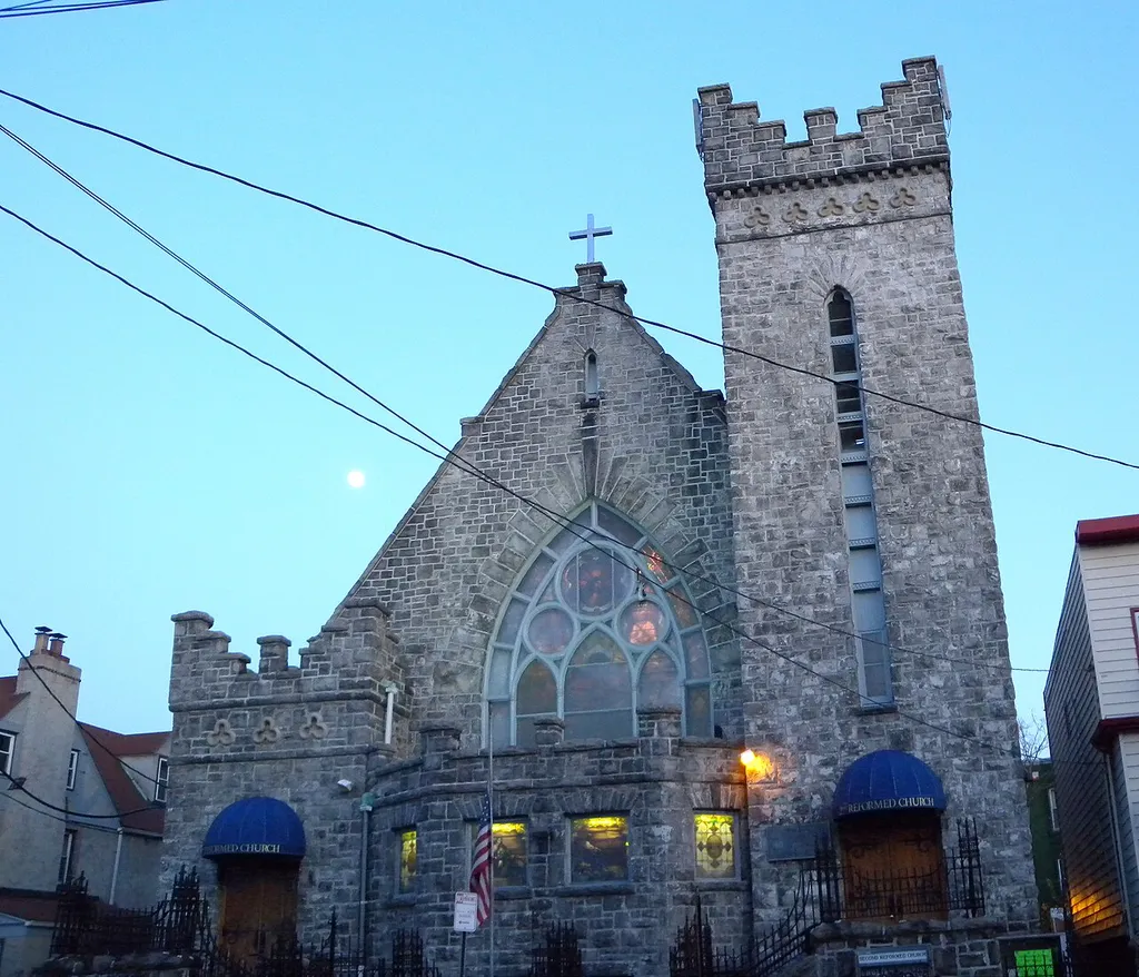 Looking east across Summit Avenue at Second Reformed Church of Jersey City in twilight of a clear evening with the Moon rising behind.