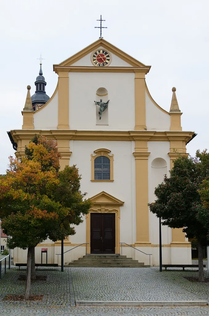 Kürnach, Kirchberg 6, Kath. Pfarrkirche St. Michael. In der Nische der Westfassade zeitgenössische Michaels-Skulptur von Karlheinz Oswald.