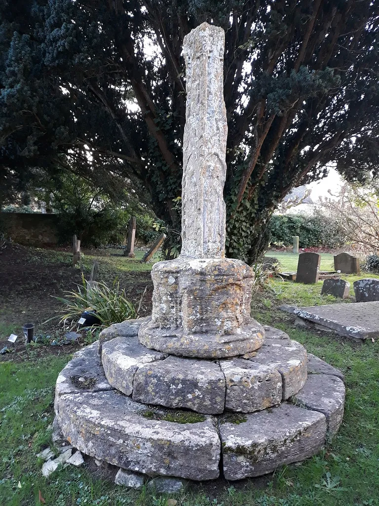 Yarnton Cross, a broken limestone shaft with heavily eroded sculpture, in the churchyard of St. Bartholomew's Church, Yarnton, Oxfordshire, England. 14th century AD.