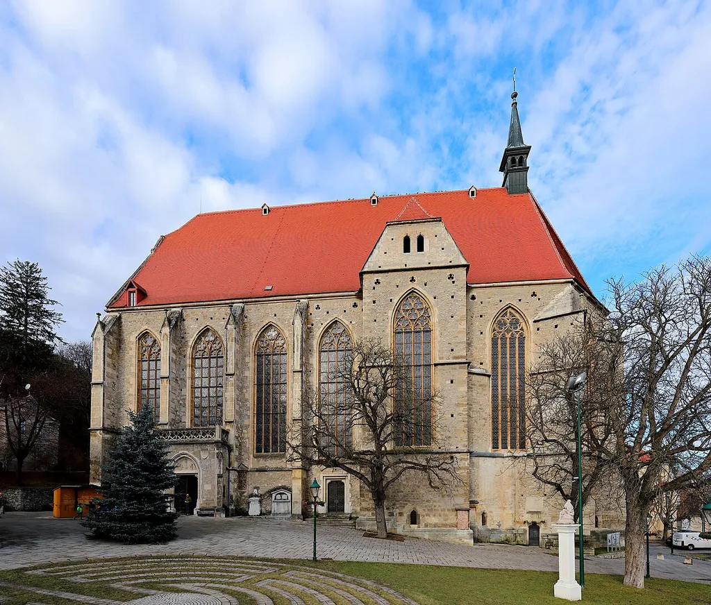 Die Südansicht der röm.-kath. Pfarrkirche St. Othmar in der niederösterreichischen Stadt Mödling und davor ein Pieta-Pfeiler aus dem Jahr 1694.Die dreischiffige, gotische Hallenkirche wurde von 1454 bis 1523 errichtet. Nach Zerstörung der Kirche 1529 durch die Osmanen wurde das Dach und Gewölbe erst im 17. Jahrhundert wieder hergestellt. 1683 erfolgte eine neuerliche Zerstörung. Der heutige Dachstuhl wurde 1690 hergestellt. Von 1875 bis 1897 erfolgte eine Generalsanierung und Regotisierung. Dabei wurden unter anderem die seit der Barockzeit vermauerten Fenster wieder freigelegt.