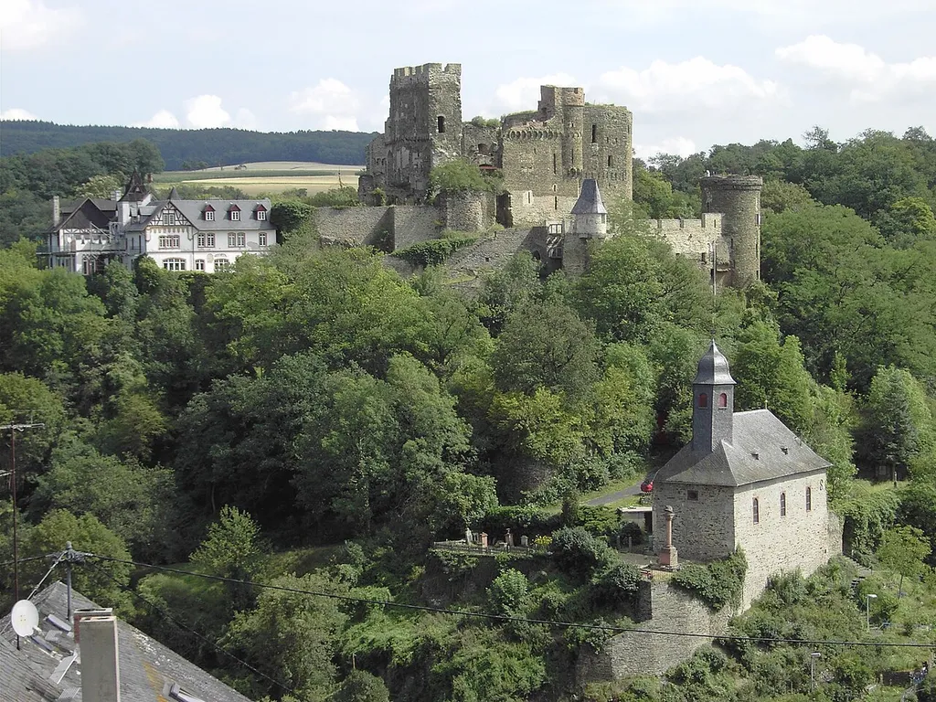 Bild der Burg Reichenberg und des Burgberges mit der BurgkapelleRechts die Burgruine, links das historisierende Wohngebäude von 1880,im Vordergrund die Burgkapelle, heute Ev. Kirche, um die Kirche das Ehrenmal, der Burgfriedhof und der Friedhof der Pächter von Hof Offenthal