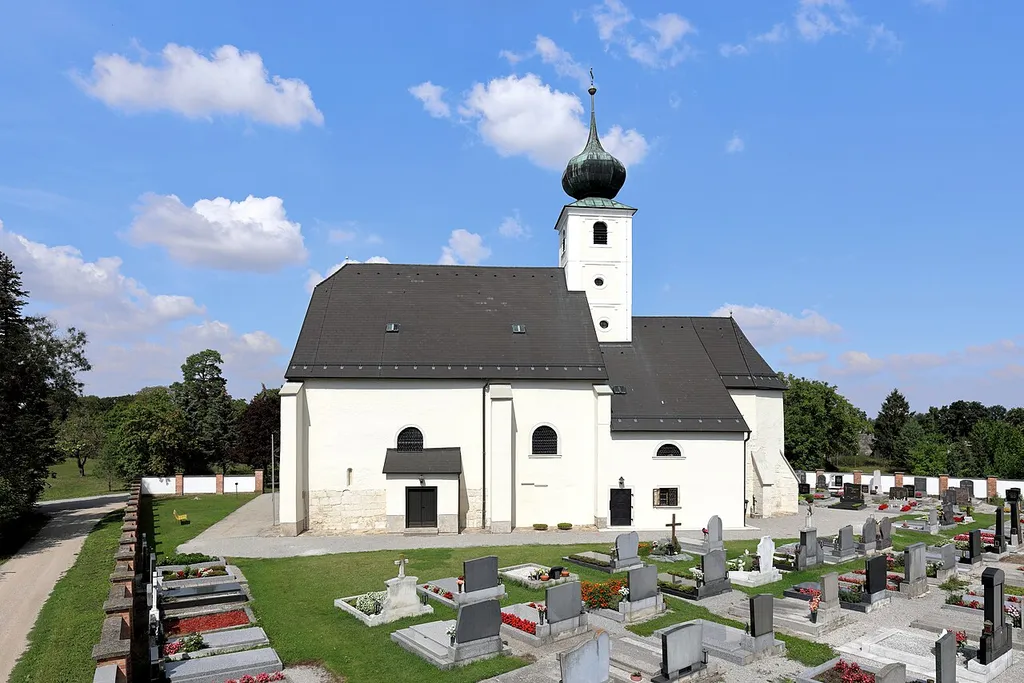 Südsüdostansicht der Pfarrkirche hl. Leonhard in der niederösterreichischen Marktgemeinde Eckartsau.Einer im Kern spätmittelalterlicher Sakralbau, der unter Beibehaltung des im Kern gotischen Chores und des vorgegebenen Grundrisses 1703 barockisiert wurde. Die im Süden angebaute zweigeschossige Sakristei wurde im 18. Jahrhundert errichtet.