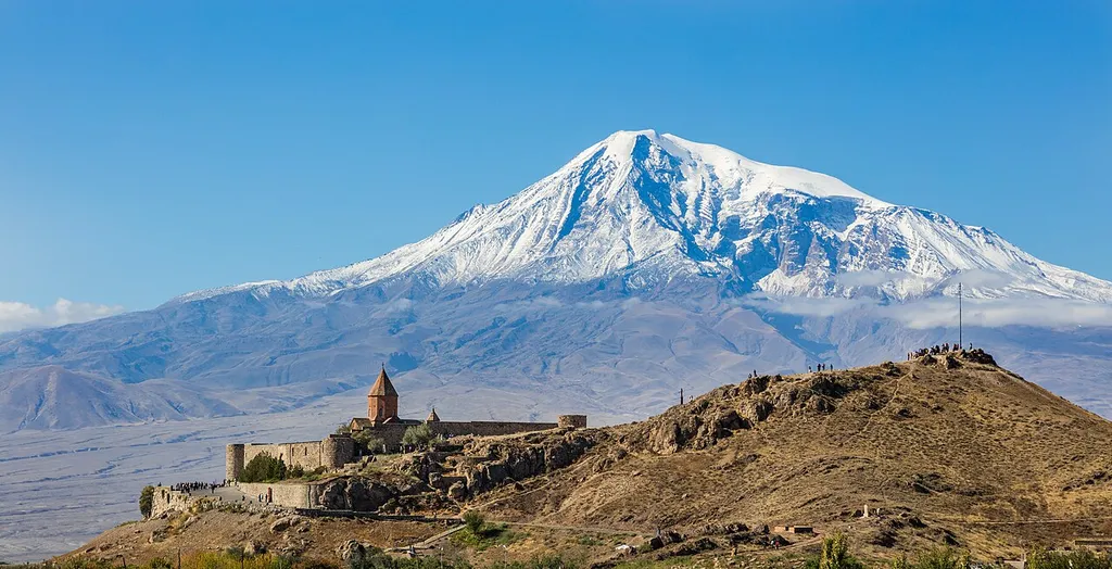 View of Khor Virap, an Armenian monastery and one of the most visited pilgrimage sites in Armenia located in the Ararat plain with Mount Ararat in the background. Khor Virap's notability as a monastery and pilgrimage site is due to the fact that Gregory the Illuminator, religious leader who converted Armenia from paganism to Christianity in 301, becoming the first nation to adopt Christianity as its official religion, was initially imprisoned here for 14 years by King Tiridates III of Armenia. A chapel was initially built in 642 by Nerses III the Builder as a mark of veneration to Saint Gregory. Over the centuries, it was repeatedly rebuilt and the current appearance dates from 1662.
