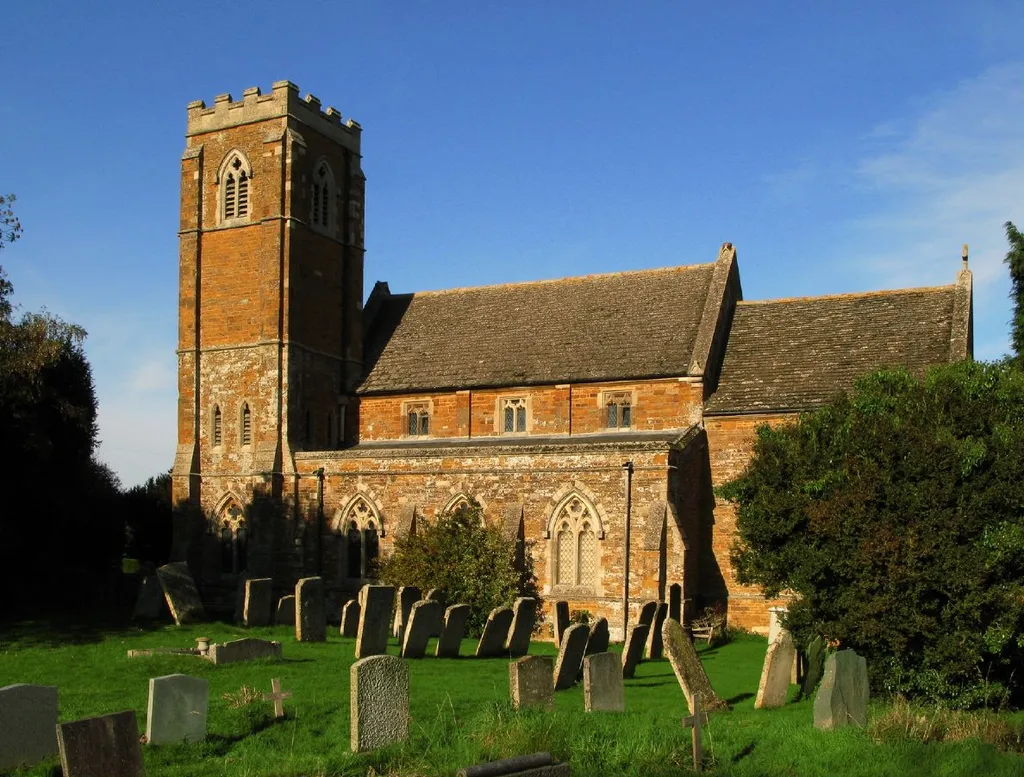 Church of England parish church of St John the Baptist, Bisbrooke, Rutland. The church was built in 1871 and the tower was completed in 1914. The churchyard has a number of Ketton oolite headstones that pre-date the present church.