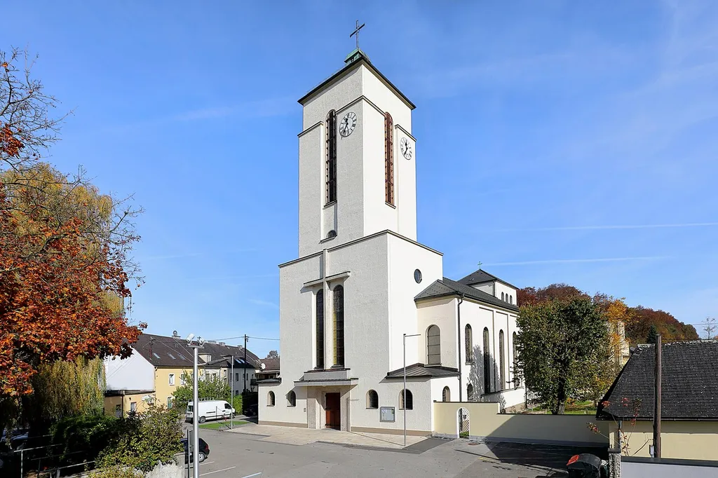 Südwestansicht der Pfarrkirche Hl. Geist in Attnang, ein Ortsteil der oberösterreichischen Stadt Attnang-Puchheim. Sie wurde von 1935 bis 1951 mit kriegsbedingter Unterbrechung und Bombenschäden nach den Plänen des Architekten Hans Feichtlbauer erbaut und am 9. September 1951 geweiht.